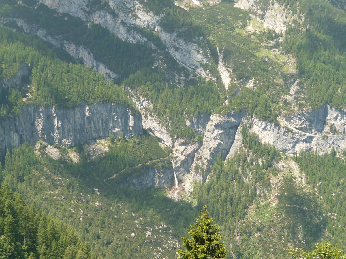 Fig. 68. La cascata delle Comelle supera il gradino di valle glaciale sospesa, impostato nella Formazione del Contrin, in parte inciso dalla gola stretta e profonda dell’Orrido delle Comelle. La fenditura subito a destra della cascata è impostata lungo un filone verticale di andesite sul quale l’erosione è stata più efficacie rispetto alla dolomia che lo circonda (Foto D.G.).