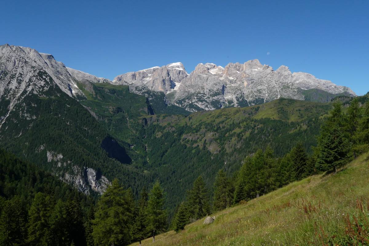 A view from Casera Gardès to Val di Reiane - a hanging glacial valley located right along the contact between the cliff escarpment of Pale del Balcon (left) in the Schlern Formation, and the volcanic and volcano-clastic rocks of Sass Negher with the crest of Cesurette-Palalada-Caoz; the Livinallongo Formation outcropping along the valley floor. After the retreat of the glaciers, landslides and streams created escarpments, ledges, waterfalls, gullies and small ravines, by operating in a mixed and complex rocky substrate. In the background the northern chain of the Pala-Group with Cima Vezzana, Cima dei Bureloni, Focobon, Cima di Campido and Monte Mulaz (photo DG). 